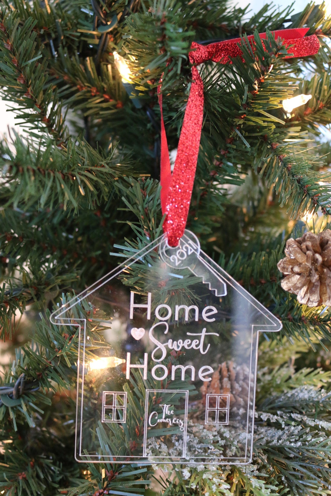 Personalized Acrylic Christmas Ornament. Made from acrylic or wood, this ornament is the perfect decoration to celebrate life’s most memorable moments. Ornaments arrive in a kraft gift box embellished with a black bow Customer design laser cut lettering with multiple ribbon options. thequinnandcompany. www.thequinnandcompany.com