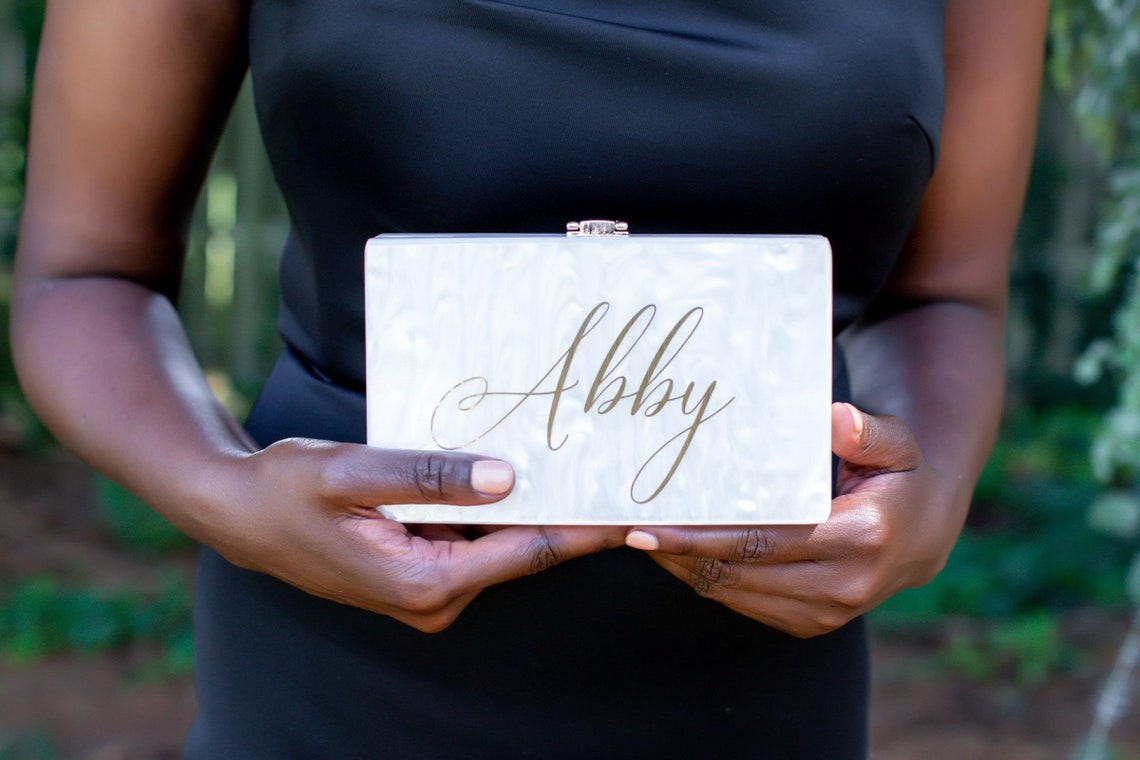 Acrylic clutch. Customizable and personalized for your wedding day. Elegant design with stylish lettering. Durable acrylic and hardware makes this clutch a necessity to carry your necessities. thequinnandcompany. www.thequinnandcompany.com